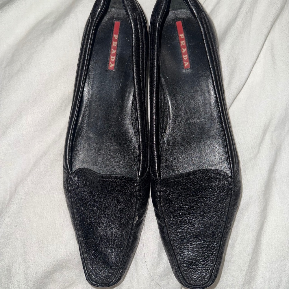 black leather loafers from the brand Prada.